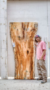 Man standing next to a spalted maple live edge slab